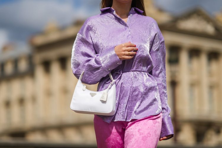 PARIS, FRANCE - MAY 23: Maria Rosaria Rizzo @lacoquetteitalienne wears silver earrings, a pale purple belted oversized MSGM silk shirt, pink flower pattern silk MSGM flared pants, a white Prada Re-edition 2000 handbag, khaki suede strappy and white seams Mou sandals platform shoes, a gold ring, on May 23, 2021 in Paris, France. (Photo by Edward Berthelot/Getty Images)