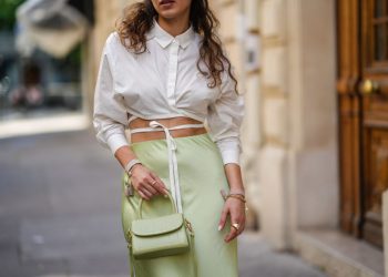 PARIS, FRANCE - JUNE 11: Ketevan Giorgadze @katie.one wears a pistachio green flowy lustrous satin midi skirt by Ottod’ame, a white cropped shirt with a crossover waist-tie by Le Ger, a mini sage green croco embossed leather bag from By far, Dior friendship bracelets in pink and cream, on June 11, 2021 in Paris, France. (Photo by Edward Berthelot/Getty Images)