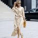 DUSSELDORF, GERMANY - JULY 14: Influencer Gitta Banko wearing a beige longsleeve silk maxi shirt dress with tied waist by P.A.R.O.S.H., a brown-orange feather bag by Marques'Almeida, yellow and black satin strappy high heel sandals by Saint Laurent, a silver watch by Cartier, sunglasses by Ray-Ban, a silver logo ring by Chanel and a gold lion necklace by Alighieri during a street style shooting on July 14, 2021 in Dusseldorf, Germany. (Photo by Streetstyleshooters/Getty Images)